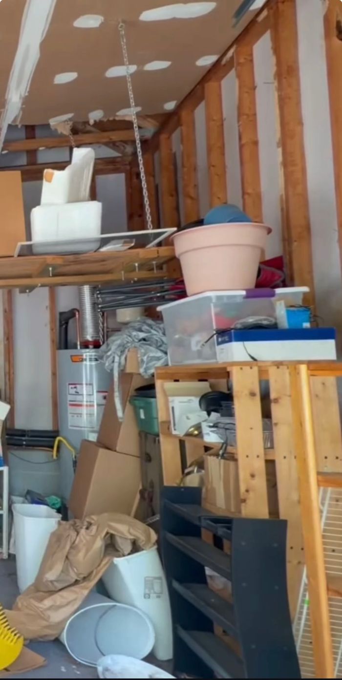 Cluttered garage before cleaning, with boxes and trash on the floor